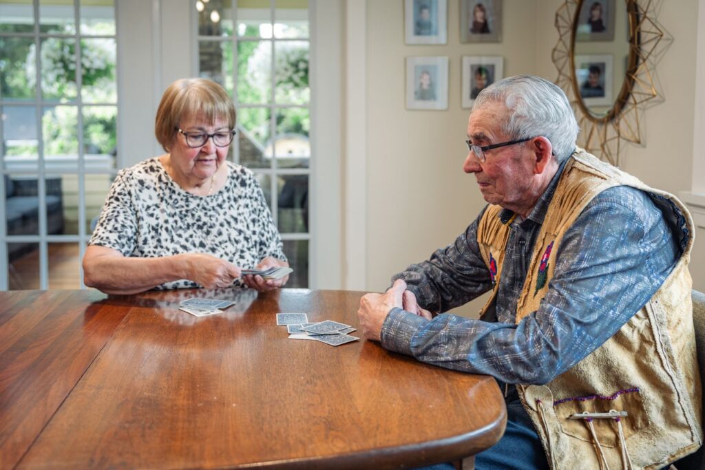 An older couple playing a card game together at a table at home